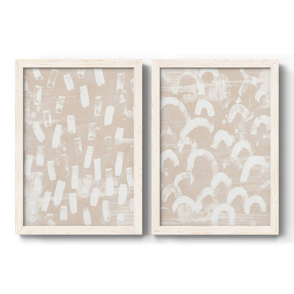 Set of two white barnwood framed canvas prints featuring two tribal-inspired pattern abstracts featuring white hand-painted dashes arcs and chevrons.