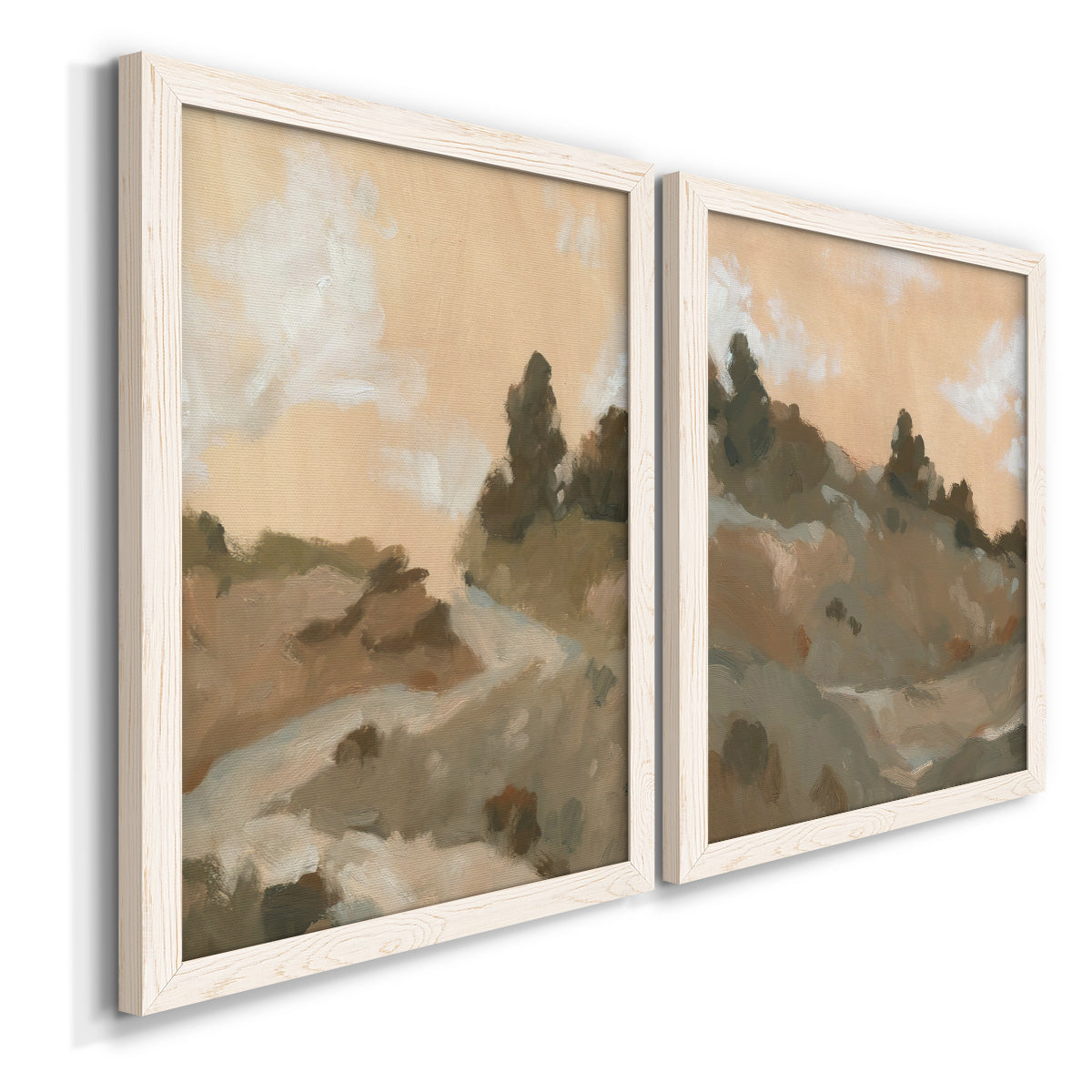 Angled view of a set of two white barnwood framed canvas prints featuring two minimalist watercolor landscapes featuring misty brown hills and winding mountain paths.