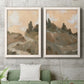 Set of two white barnwood framed canvas prints depicting a coordinated art pair of misty brown hills and winding mountain paths rendered as minimalist watercolor landscapes above a sofa in a modern living room.