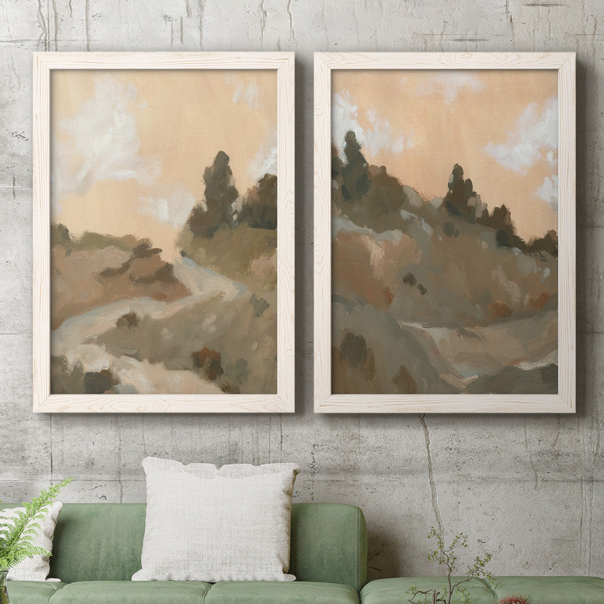 Set of two white barnwood framed canvas prints depicting a coordinated art pair of misty brown hills and winding mountain paths rendered as minimalist watercolor landscapes above a sofa in a modern living room.