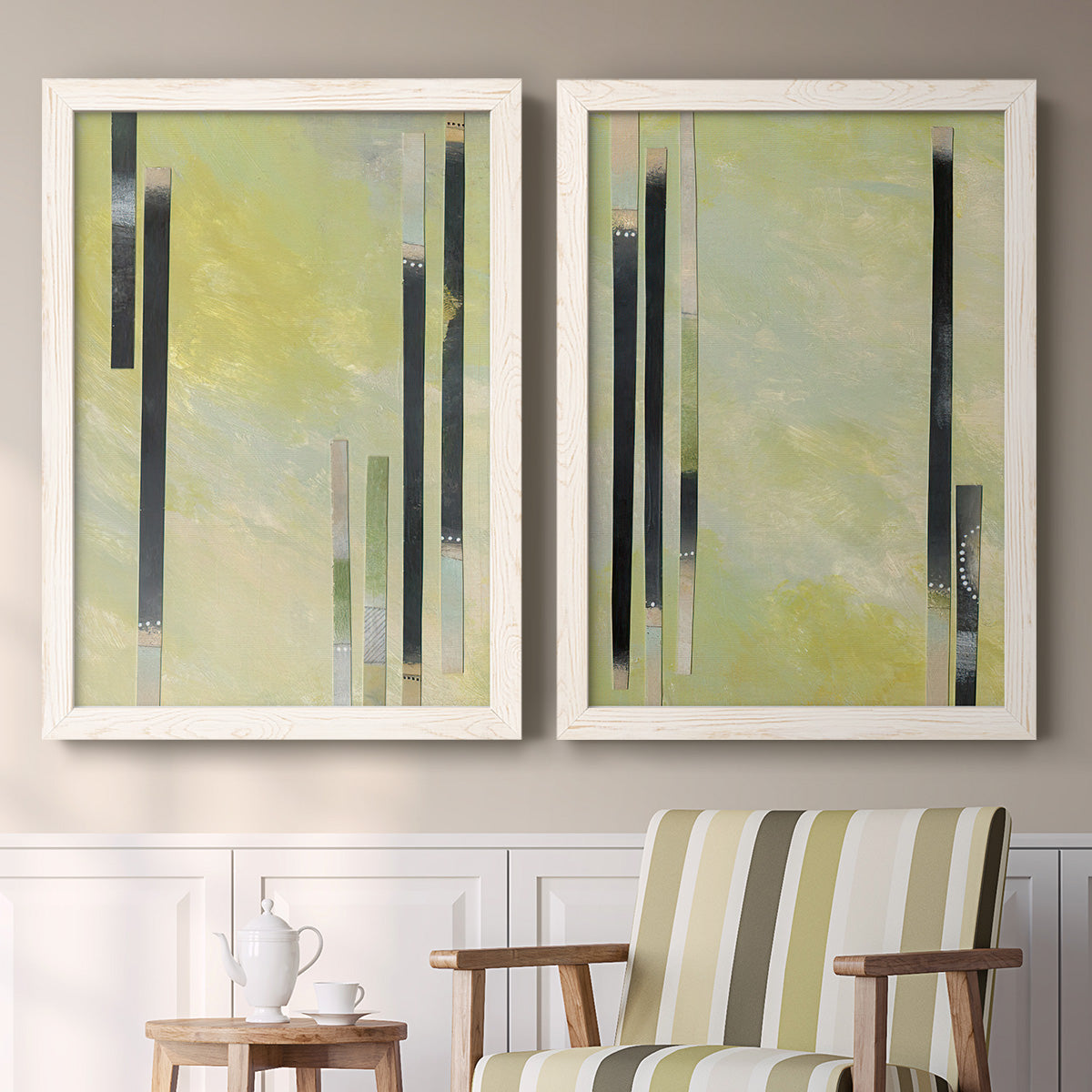 Set of two white barnwood framed canvas prints depicting two minimalist architectural abstracts featuring vertical black gray and olive bars above a sideboard in a cozy sitting room.