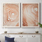 Set of two white barnwood framed canvas prints depicting a coordinated art pair of concentric wood-grain rings and rippling contour lines rendered as minimalist marbled pattern abstracts above a dining room sideboard.