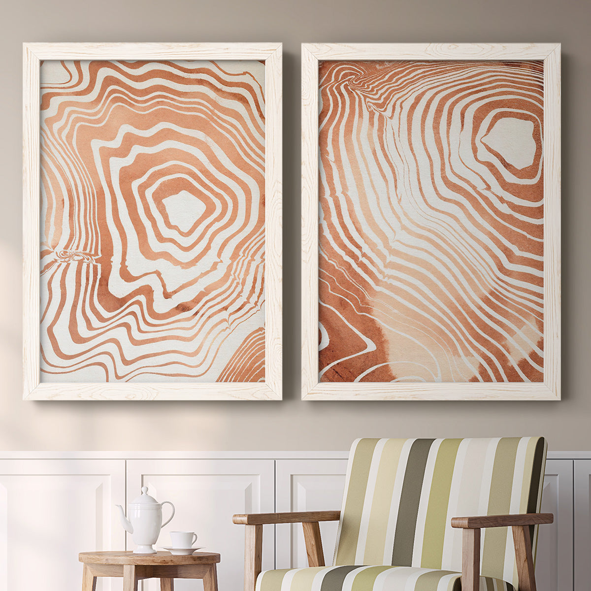 Set of two white barnwood framed canvas prints depicting two minimalist marbled pattern abstracts featuring concentric wood-grain rings and rippling contour lines above a sideboard in a cozy sitting room.