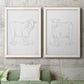 Set of two white barnwood framed canvas prints depicting a coordinated art pair of simple contour drawings of standing cows rendered as minimalist livestock sketches above a sofa in a modern living room.