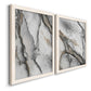 Angled view of a set of two white barnwood framed canvas prints featuring two marbled alcohol ink abstracts with flowing black gray white and metallic gold veining.