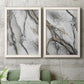 Set of two white barnwood framed canvas prints depicting a monochrome abstract pair of smoky ink washes fractured lines and warm gold accents above a sofa in a modern living room.