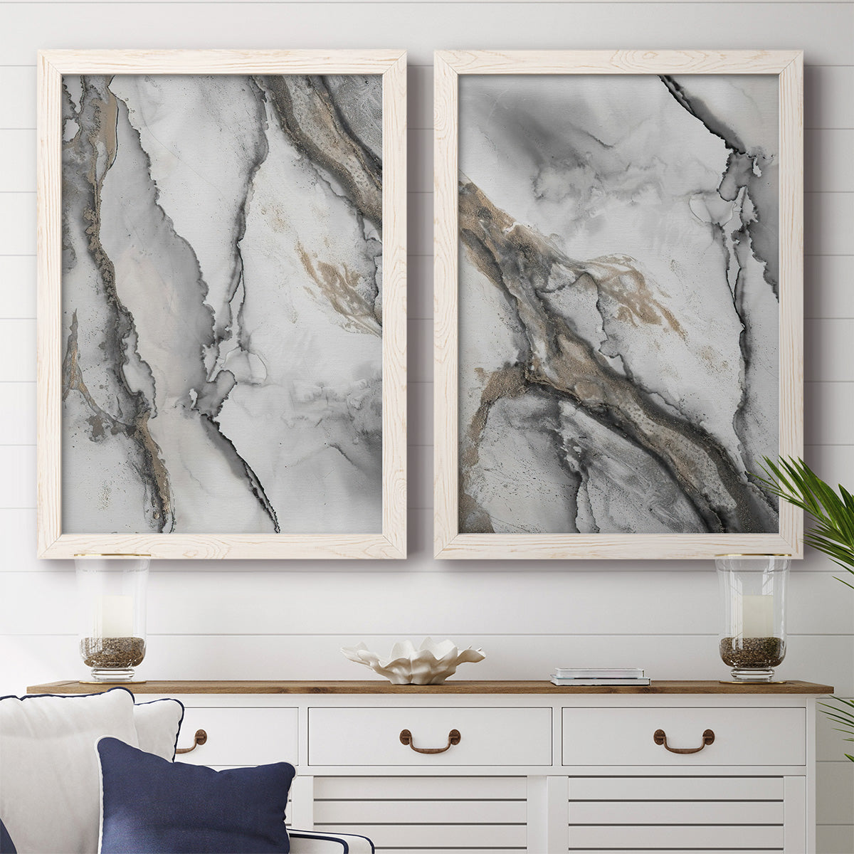 Set of two white barnwood framed canvas prints depicting a monochrome abstract pair of smoky ink washes fractured lines and warm gold accents above a dining room sideboard.