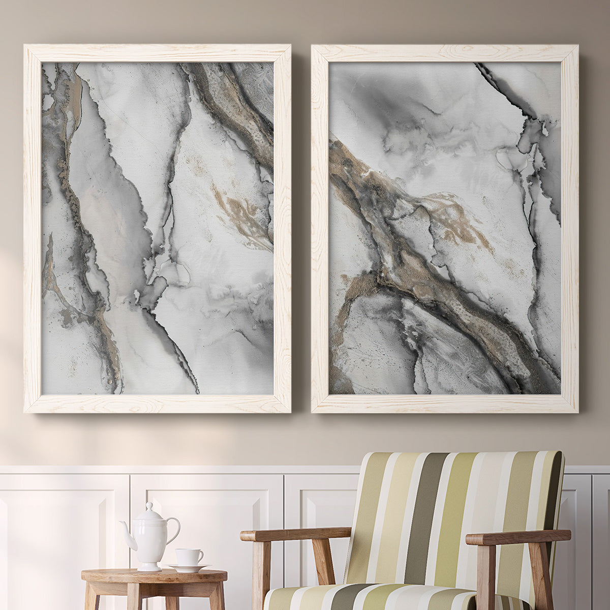 Set of two white barnwood framed canvas prints depicting two marbled alcohol ink abstracts with flowing black gray white and metallic gold veining above a sideboard in a cozy sitting room.