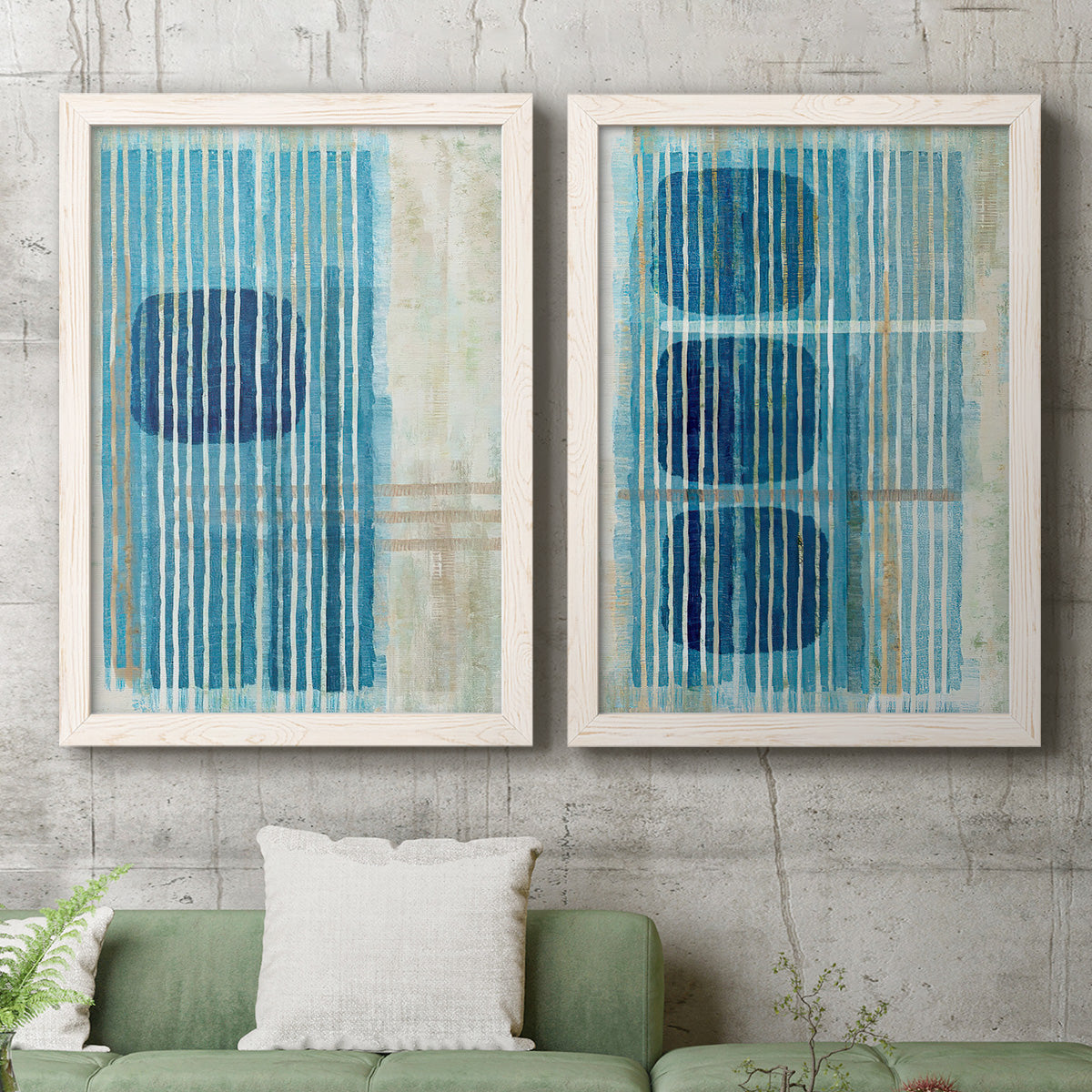 Set of two white barnwood framed canvas prints depicting a coordinated art pair of stacked blue ovals behind fine vertical stripes rendered as graphic geometric abstracts above a sofa in a modern living room.