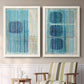 Set of two white barnwood framed canvas prints depicting two graphic geometric abstracts featuring stacked blue ovals behind fine vertical stripes above a sideboard in a cozy sitting room.