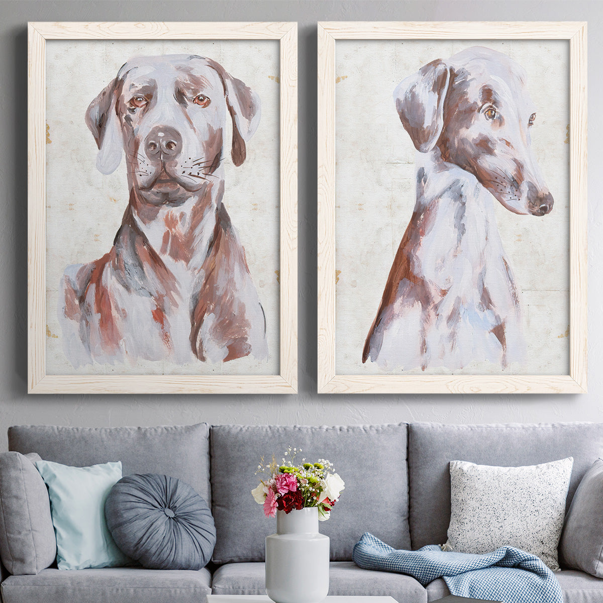 Set of two white barnwood framed canvas prints depicting paired traditional watercolor pet paintings with soft brown and gray fur, expressive faces, and lightly distressed cream grounds above a sofa in a contemporary living room.