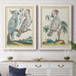 Set of two white barnwood framed canvas prints depicting a coordinated art pair of misty blue gray and violet marks hovering across pale grounds rendered as atmospheric abstract paintings above a dining room sideboard.