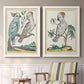 Set of two white barnwood framed canvas prints depicting two atmospheric abstract paintings featuring misty blue gray and violet marks hovering across pale grounds above a sideboard in a cozy sitting room.
