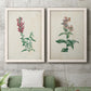 Set of two white barnwood framed canvas prints depicting antique floral illustrations featuring a tall red bloom and a clustered mauve flower above a sofa in a modern living room.