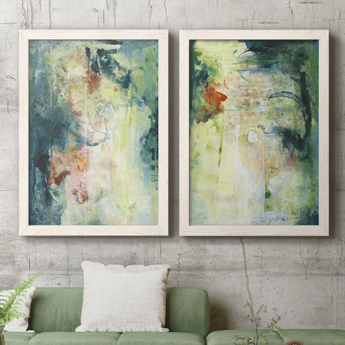 Set of two white barnwood framed canvas prints depicting a coordinated art pair of layered blue green cream and charcoal textures rendered as nature-inspired mixed-media abstracts above a sofa in a modern living room.