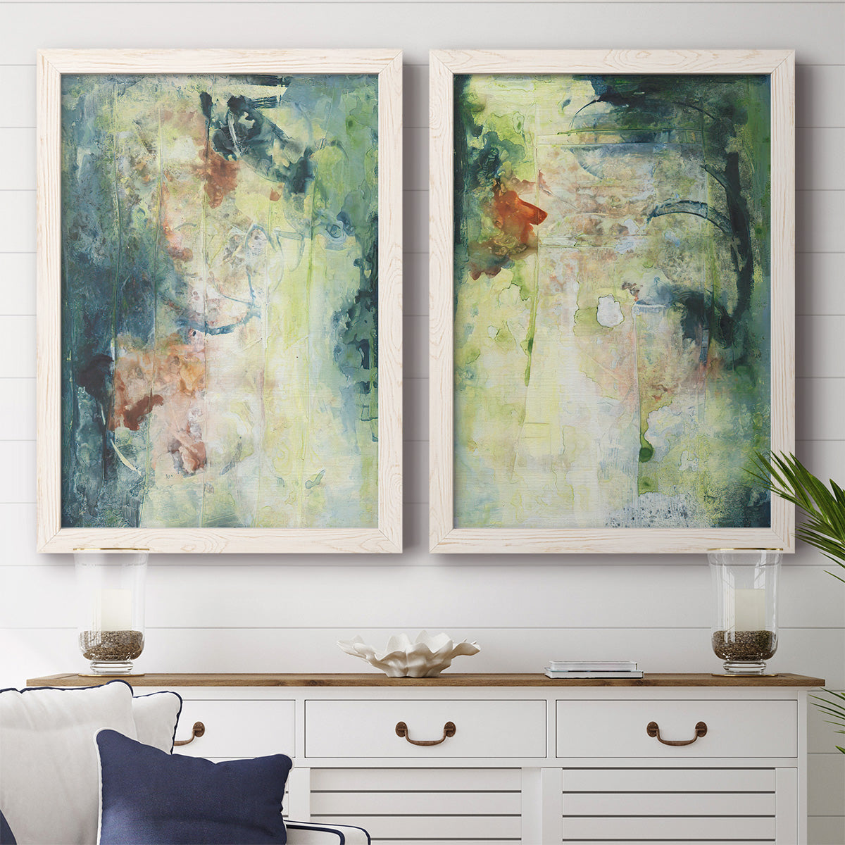 Set of two white barnwood framed canvas prints depicting a coordinated art pair of layered blue green cream and charcoal textures rendered as nature-inspired mixed-media abstracts above a dining room sideboard.