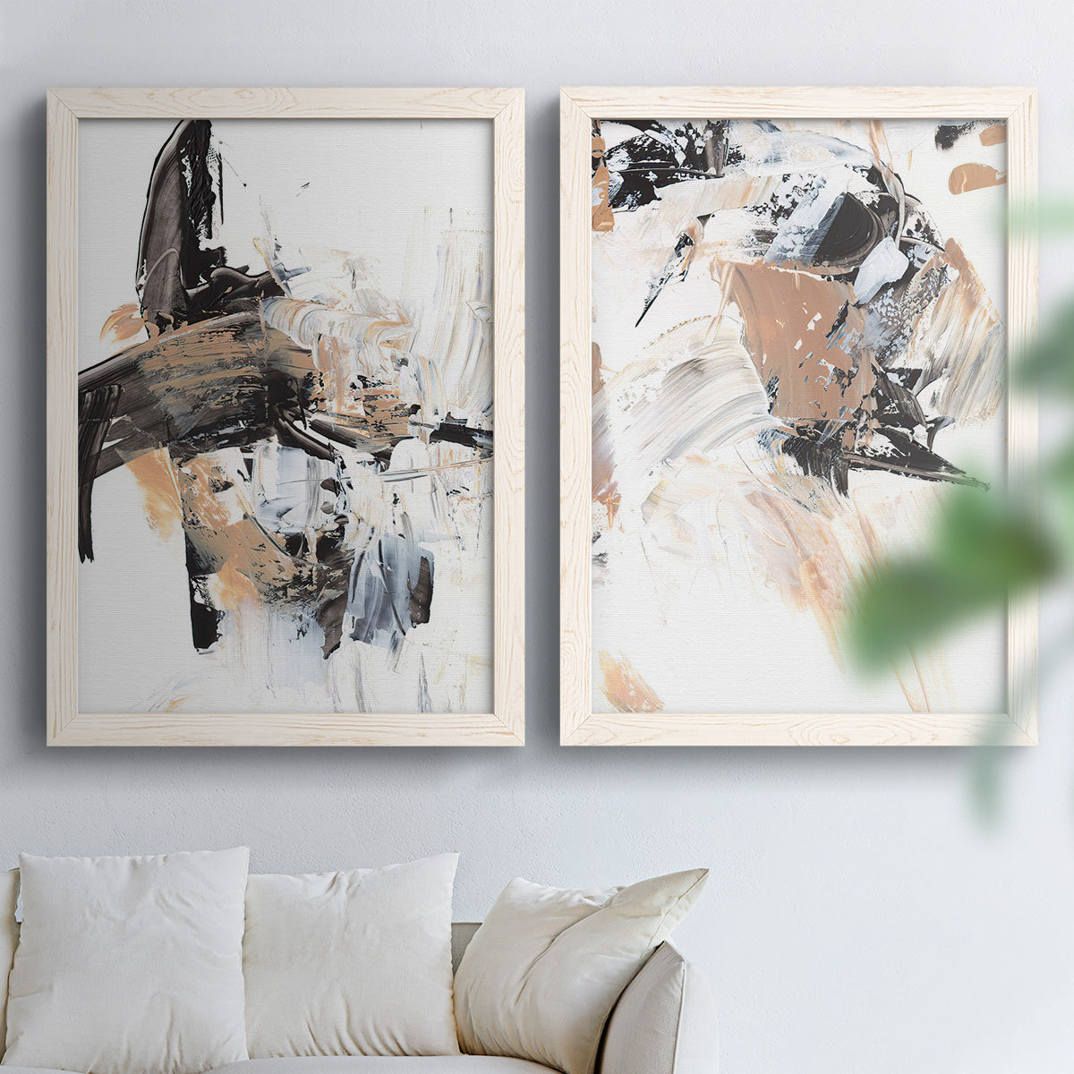 Set of two white barnwood framed canvas prints depicting sweeping brushwork, scraped passages, and layered neutral marks arranged across two complementary compositions above a sofa in a bright living space.