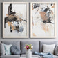 Set of two white barnwood framed canvas prints depicting paired bold mixed-media abstracts with sweeping brushwork, scraped passages, and layered neutral marks above a sofa in a contemporary living room.