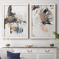 Set of two white barnwood framed canvas prints depicting a coordinated art pair of energetic black white tan and gray painted gestures rendered as bold mixed-media abstracts above a dining room sideboard.