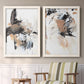Set of two white barnwood framed canvas prints depicting two bold mixed-media abstracts featuring energetic black white tan and gray painted gestures above a sideboard in a cozy sitting room.