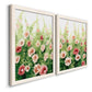 Angled view of a set of two white barnwood framed canvas prints featuring two luminous impressionistic floral paintings featuring a field of pink coral and white flowers.