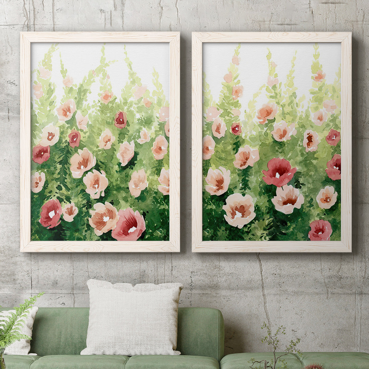 Set of two white barnwood framed canvas prints depicting a coordinated art pair of a field of pink coral and white flowers rendered as luminous impressionistic floral paintings above a sofa in a modern living room.