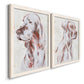 Angled view of a set of two white barnwood framed canvas prints featuring two traditional watercolor pet paintings featuring gentle seated dog portraits.