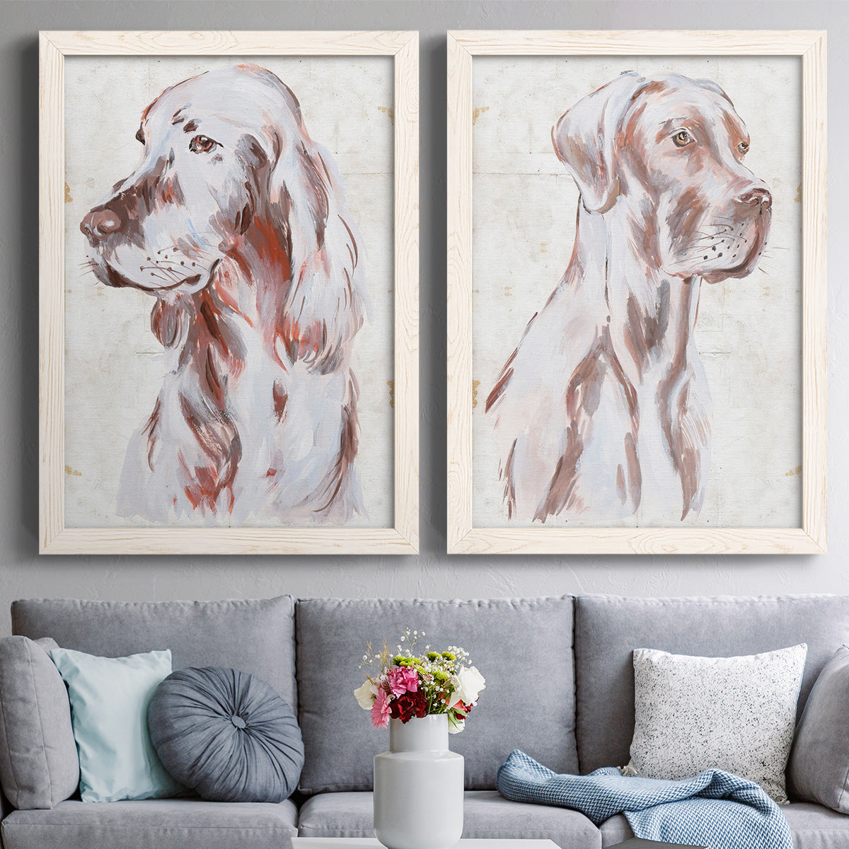 Set of two white barnwood framed canvas prints depicting paired traditional watercolor pet paintings with soft brown and gray fur, expressive faces, and lightly distressed cream grounds above a sofa in a contemporary living room.