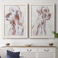 Set of two white barnwood framed canvas prints depicting a coordinated art pair of gentle seated dog portraits rendered as traditional watercolor pet paintings above a dining room sideboard.
