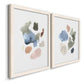 Angled view of a set of two white barnwood framed canvas prints featuring two airy minimalist abstracts featuring scattered translucent watercolor shapes.
