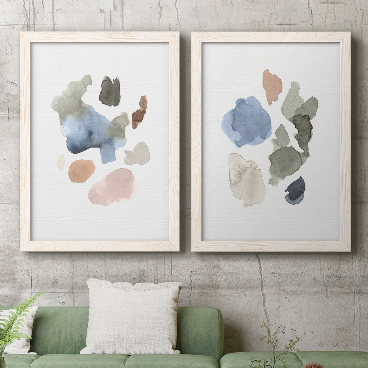 Set of two white barnwood framed canvas prints depicting a coordinated art pair of scattered translucent watercolor shapes rendered as airy minimalist abstracts above a sofa in a modern living room.
