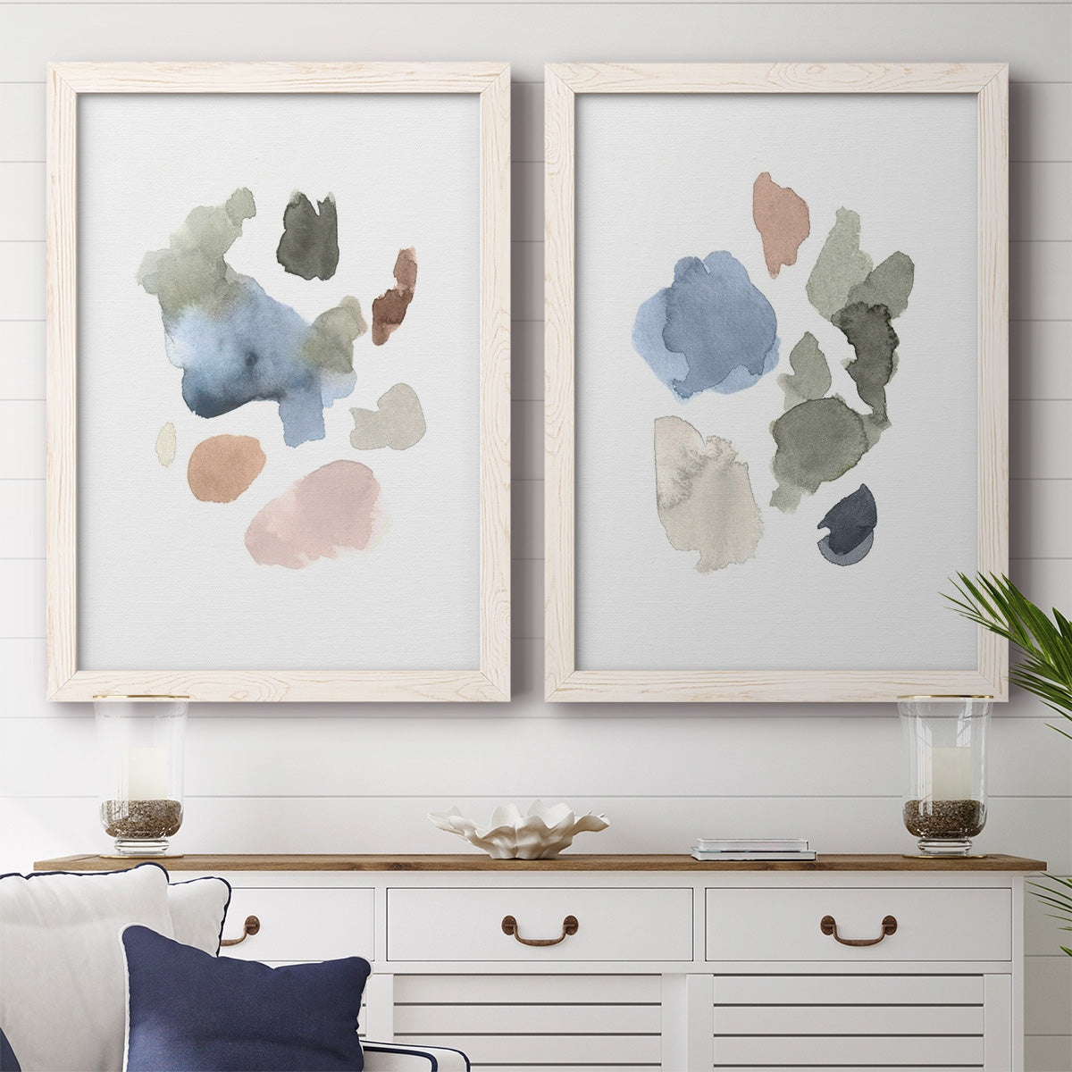 Set of two white barnwood framed canvas prints depicting a coordinated art pair of scattered translucent watercolor shapes rendered as airy minimalist abstracts above a dining room sideboard.
