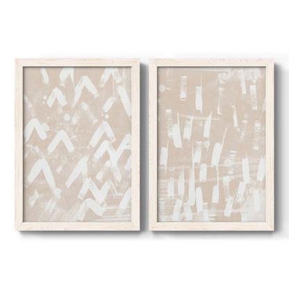 Set of two white barnwood framed canvas prints featuring two tribal-inspired pattern abstracts featuring white hand-painted dashes arcs and chevrons.