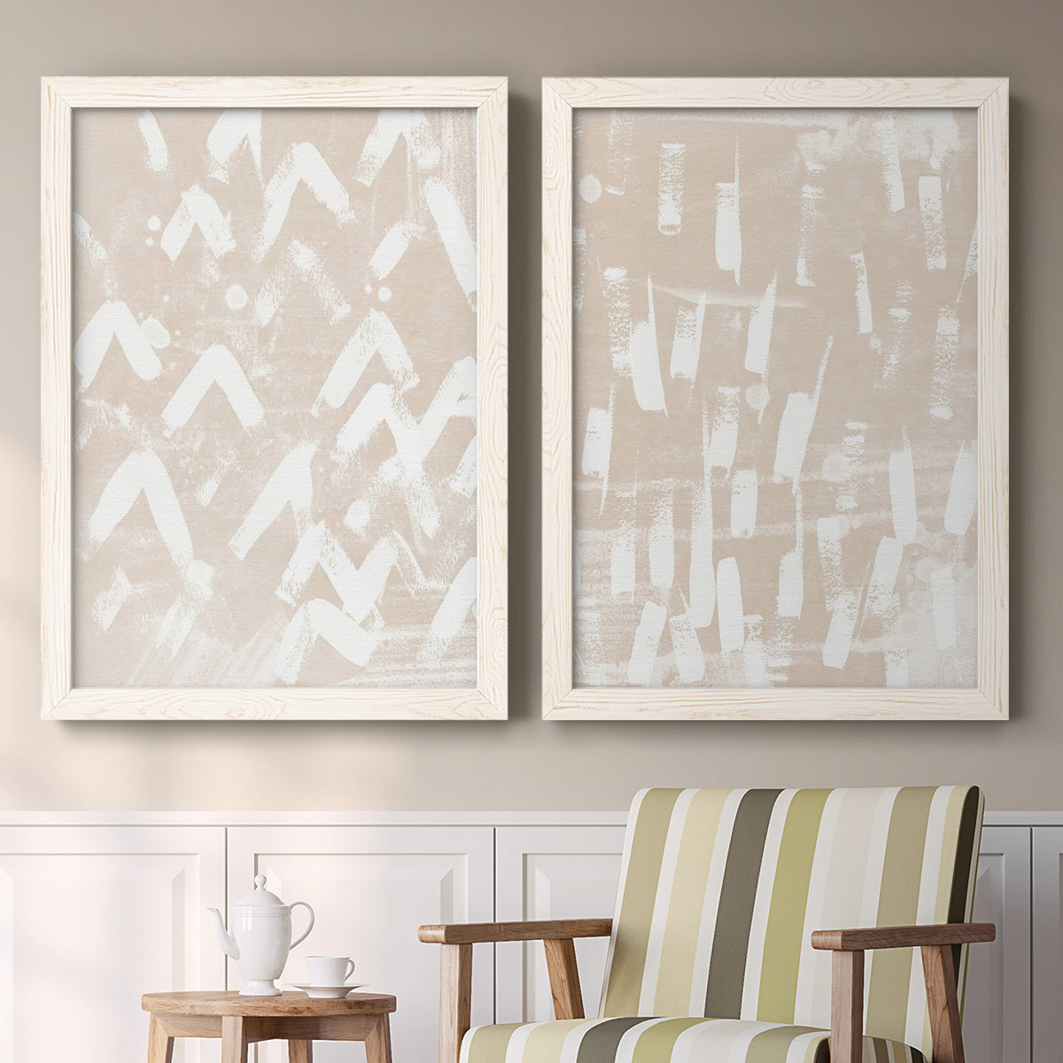 Set of two white barnwood framed canvas prints depicting two tribal-inspired pattern abstracts featuring white hand-painted dashes arcs and chevrons above a sideboard in a cozy sitting room.