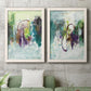 Set of two white barnwood framed canvas prints depicting a coordinated art pair of layered green purple and gray painterly forms rendered as expressive contemporary abstracts above a sofa in a modern living room.