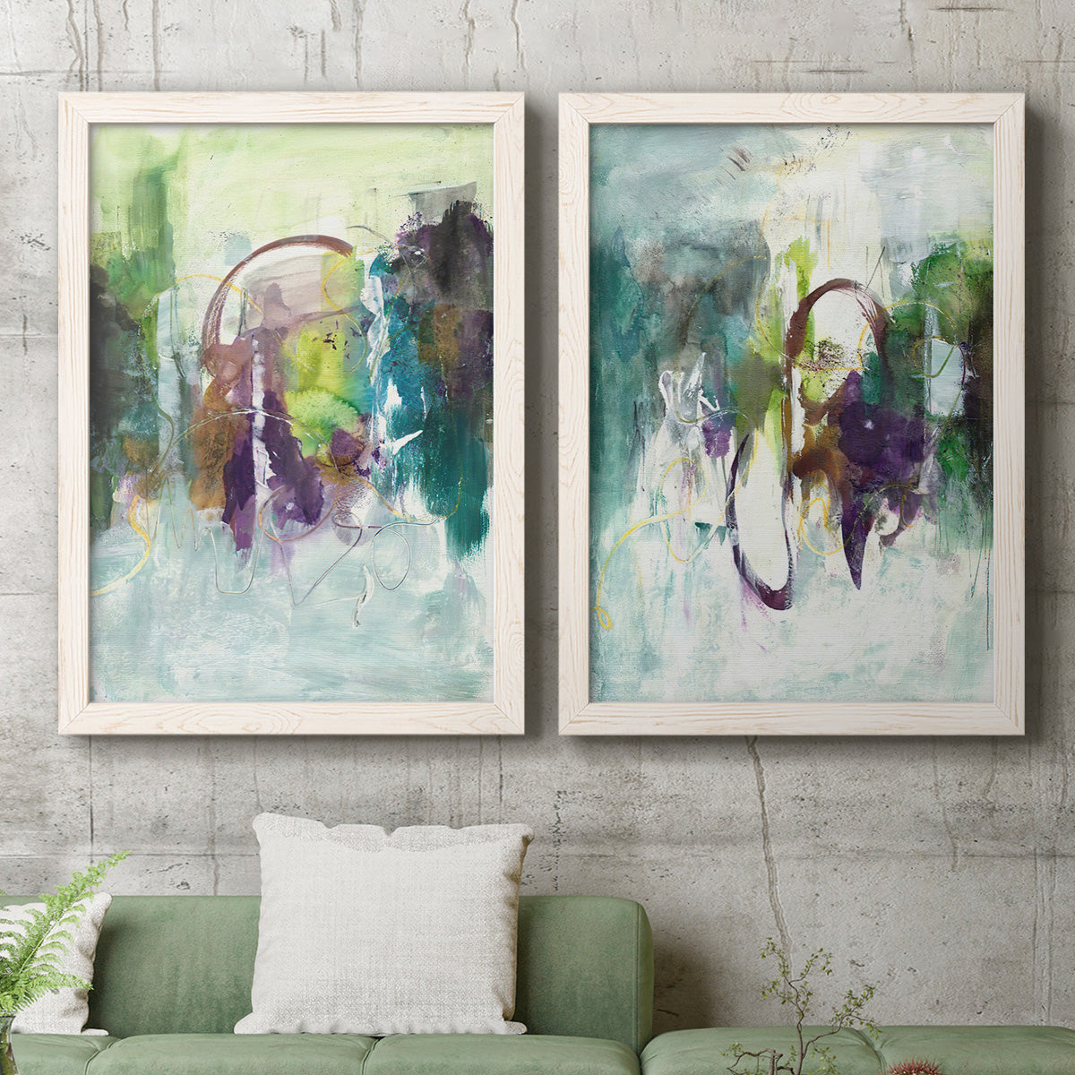Set of two white barnwood framed canvas prints depicting a coordinated art pair of layered green purple and gray painterly forms rendered as expressive contemporary abstracts above a sofa in a modern living room.