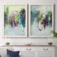 Set of two white barnwood framed canvas prints depicting a coordinated art pair of layered green purple and gray painterly forms rendered as expressive contemporary abstracts above a dining room sideboard.