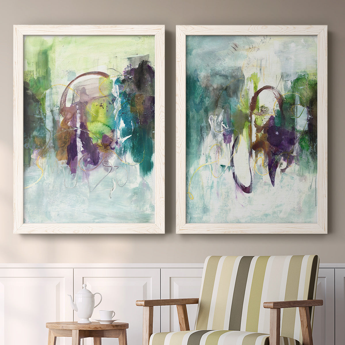 Set of two white barnwood framed canvas prints depicting two expressive contemporary abstracts featuring layered green purple and gray painterly forms above a sideboard in a cozy sitting room.