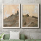 Set of two white barnwood framed canvas prints depicting a coordinated art pair of misty brown hills and winding mountain paths rendered as minimalist watercolor landscapes above a sofa in a modern living room.