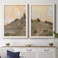 Set of two white barnwood framed canvas prints depicting a coordinated art pair of misty brown hills and winding mountain paths rendered as minimalist watercolor landscapes above a dining room sideboard.