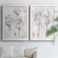 Set of two white barnwood framed canvas prints depicting scribbled outlines, creamy paint, and delicate warm accents arranged across two complementary compositions above a sofa in a bright living space.