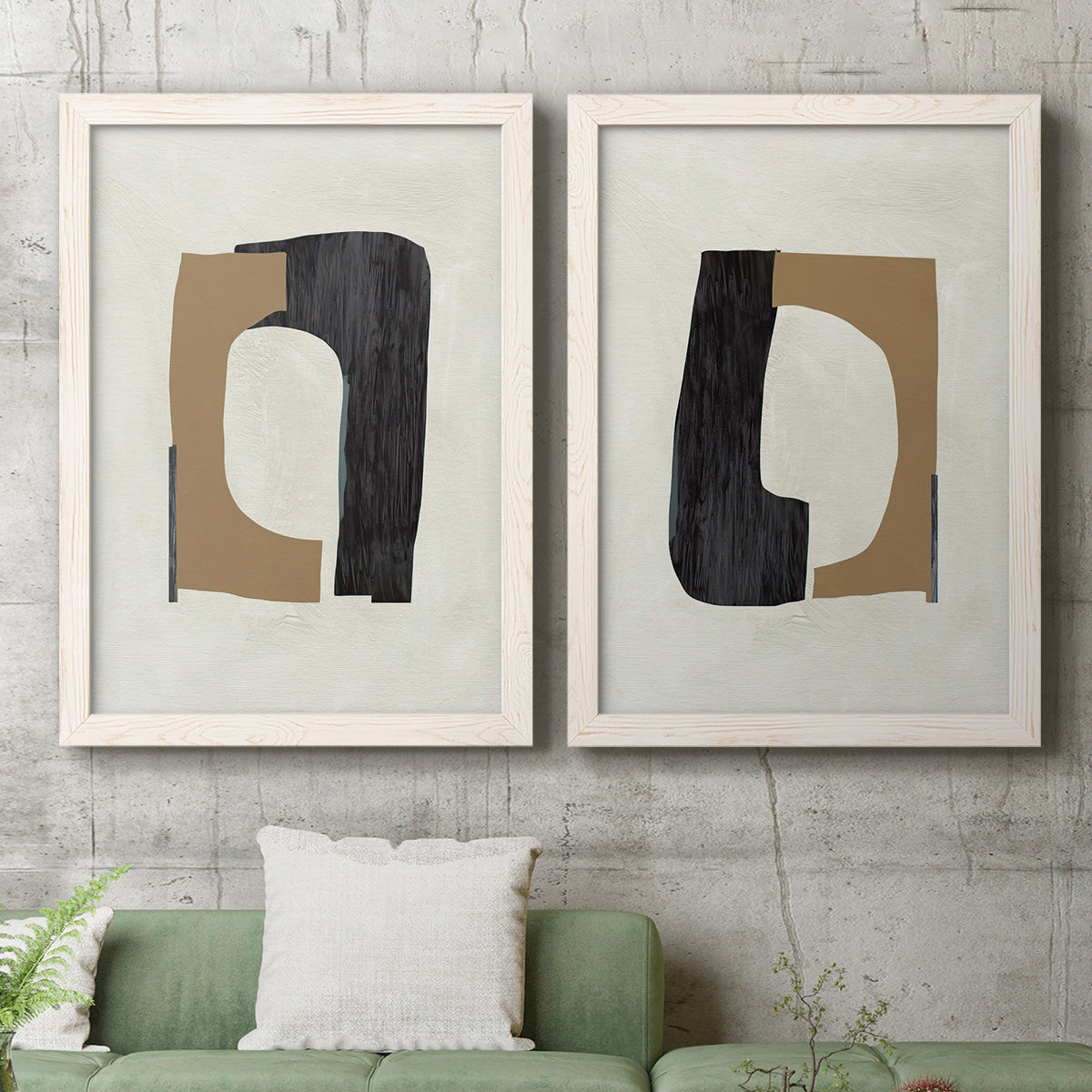 Set of two white barnwood framed canvas prints depicting a coordinated art pair of black brown and cream cutout-like forms rendered as minimalist geometric collage abstracts above a sofa in a modern living room.