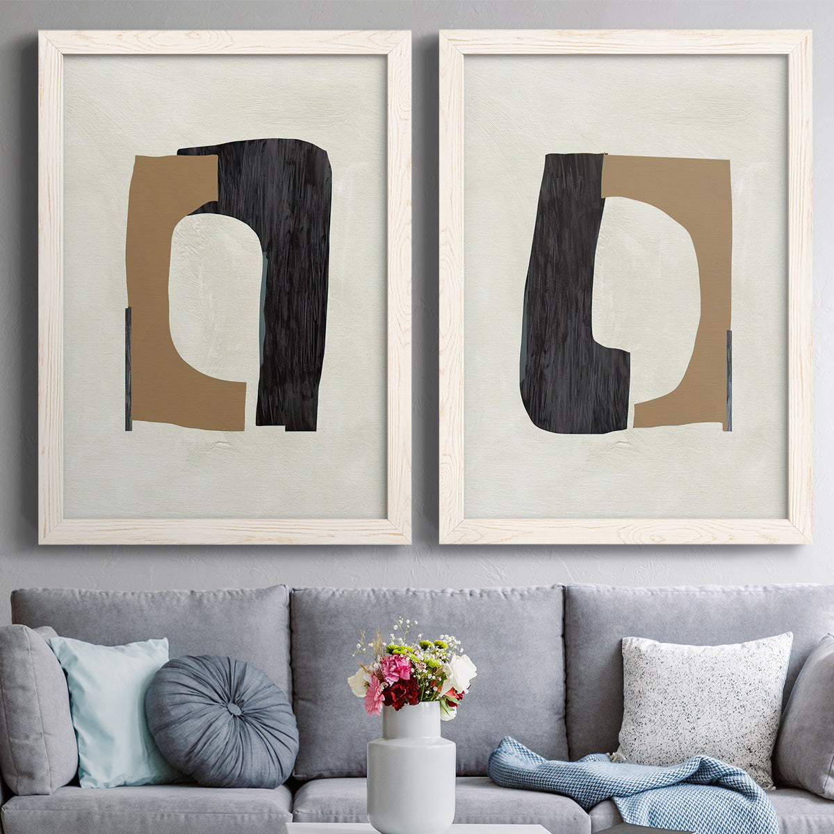 Set of two white barnwood framed canvas prints depicting paired minimalist geometric collage abstracts with flat rounded rectangles, irregular openings, and warm paper texture above a sofa in a contemporary living room.