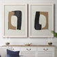 Set of two white barnwood framed canvas prints depicting a coordinated art pair of black brown and cream cutout-like forms rendered as minimalist geometric collage abstracts above a dining room sideboard.