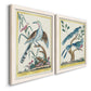 Angled view of a set of two white barnwood framed canvas prints featuring two antique ornithological plate illustrations featuring vintage exotic birds perched in landscape settings.