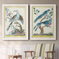 Set of two white barnwood framed canvas prints depicting two antique ornithological plate illustrations featuring vintage exotic birds perched in landscape settings above a sideboard in a cozy sitting room.