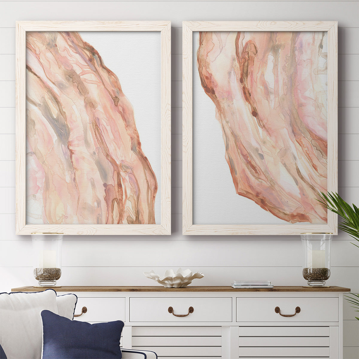 Set of two white barnwood framed canvas prints depicting a coordinated art pair of flowing blush peach and cream mineral bands rendered as soft marble-inspired abstracts above a dining room sideboard.