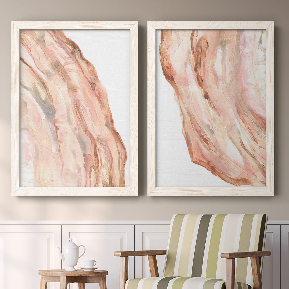 Set of two white barnwood framed canvas prints depicting two soft marble-inspired abstracts featuring flowing blush peach and cream mineral bands above a sideboard in a cozy sitting room.