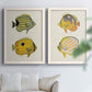 Set of two white barnwood framed canvas prints depicting striped yellow gray and orange bodies on pale archival paper arranged across two complementary compositions above a sofa in a bright living space.