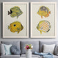 Set of two white barnwood framed canvas prints depicting paired natural-history fish illustrations with striped yellow gray and orange bodies on pale archival paper above a sofa in a contemporary living room.